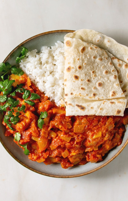 Jackfruit-Curry mit Reis, Fladenbrot und Koriander in einer Schüssel