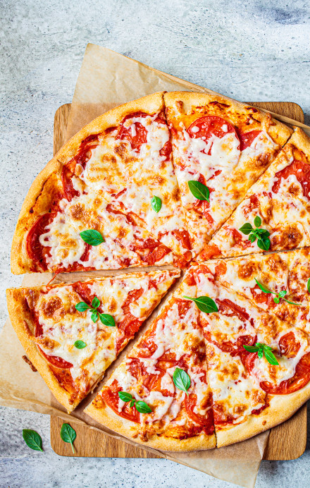 Zugeschnittene Pizza Margherita auf einem Brett
