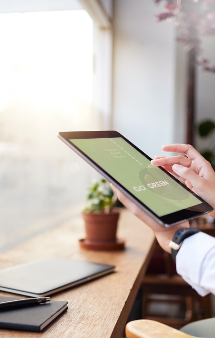 Mann hält Tablet vor einer Fensterfront