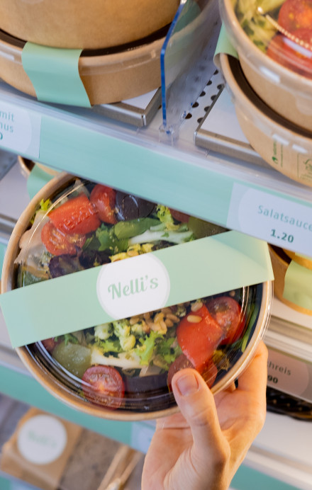 Salat im Take Out Geschirr wird aus einem Smart Fridge genommen