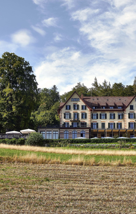 Sorell Hotel Zürichberg von aussen, Ansicht mit opulenten Hochstammobstbäumen dahinter und grünen Wiesen davor