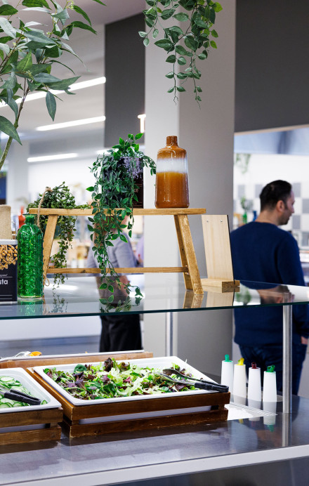 Zwei Männer hinter einem Buffet mit frischem Salat an der Essensausgabe