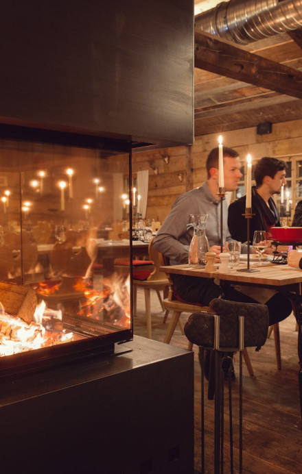 Cheminée mit Restauranttischen im Hintergrund