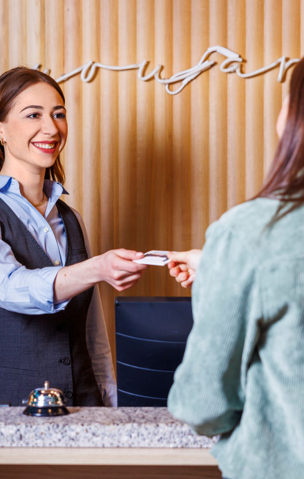 Junge Frau an der Reception beim Check-in