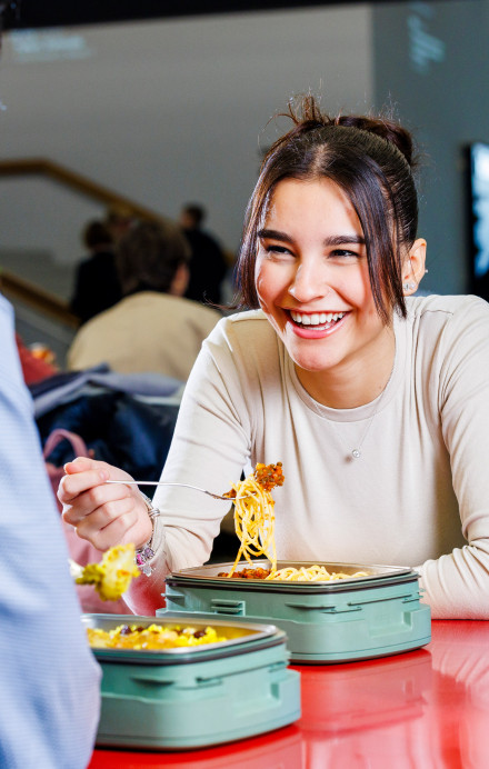 Junges Paar isst gemeinsam mitgebrachtes Essen