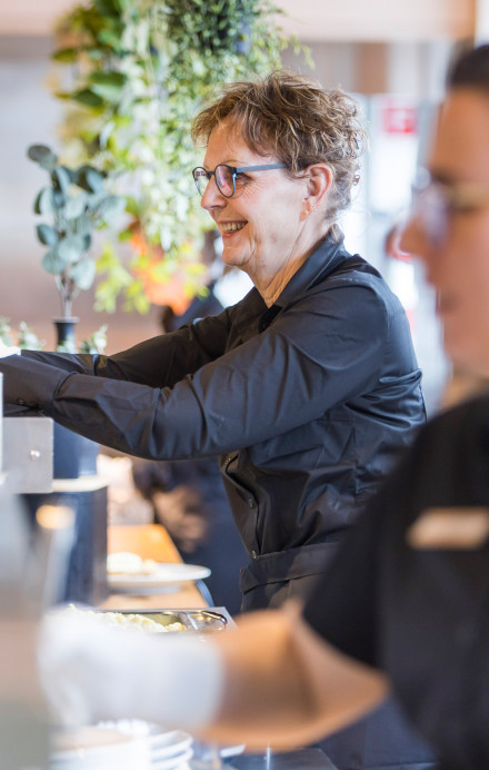 Zwei Frauen bedienen an einer Essensausgabe