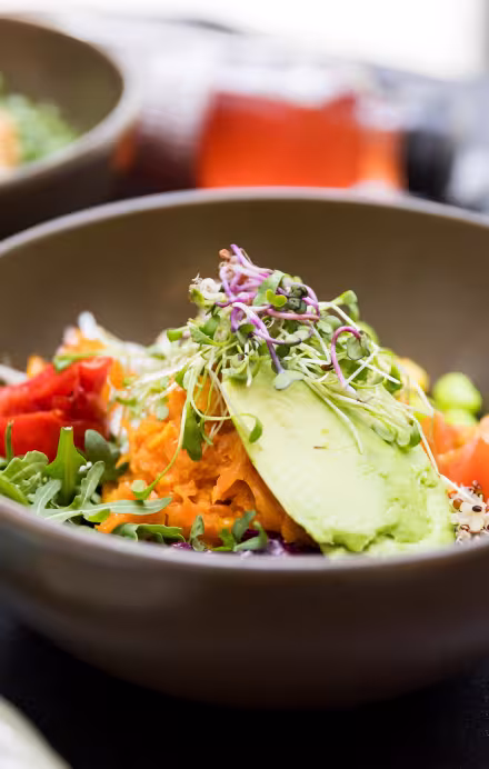 Bowl mit veganem Gericht angerichtet auf einem Tableau