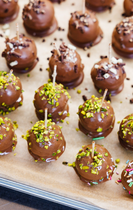 Cakepops mit Schokoladenglasur und Streuseln auf einem Blech