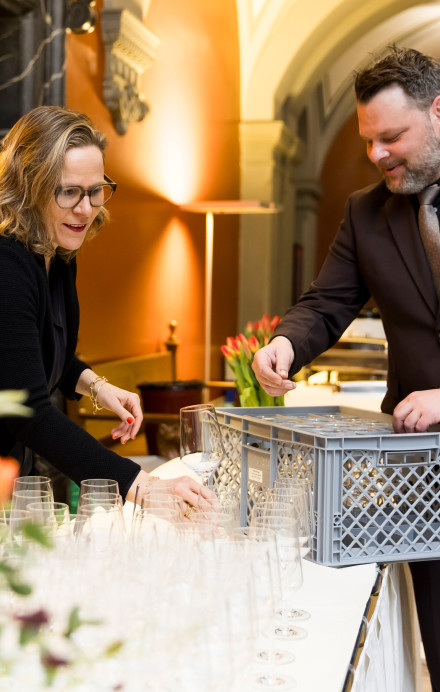 Zwei Personen bauen ein Buffet auf