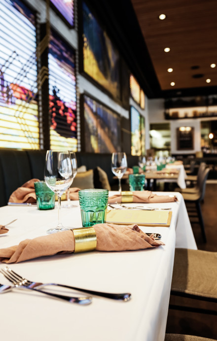 Innenansicht Brasserie im Verkehrshaus mit gedecktem Tisch und Bildern von Mobilität an der Wand