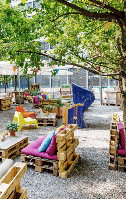 Bunter Sommergarten im Innenhof des Axa Superblocks mit DIY-Möbeln und Foodtrucks