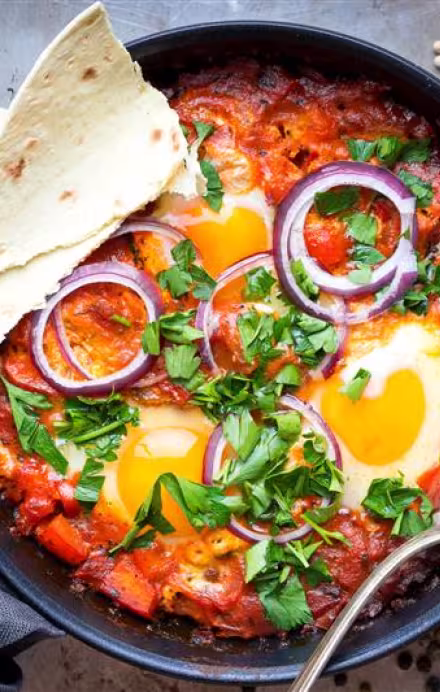 Pfanne mit Shakshuka und Fladenbrot