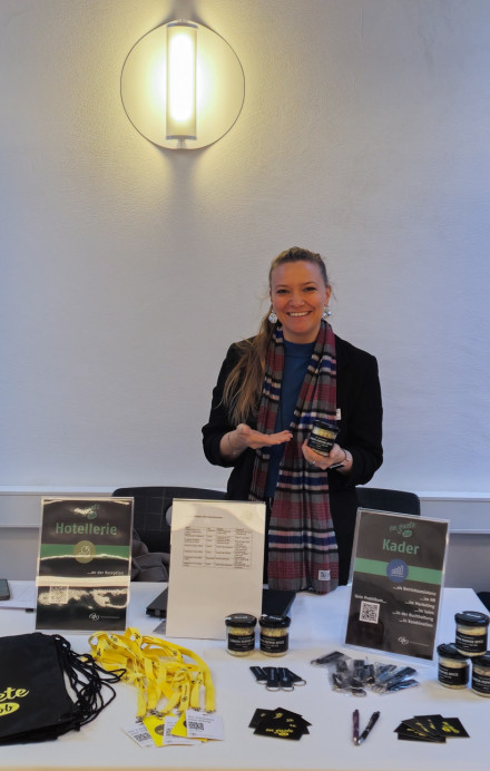 Frau steht an einem Stand mit Plakaten