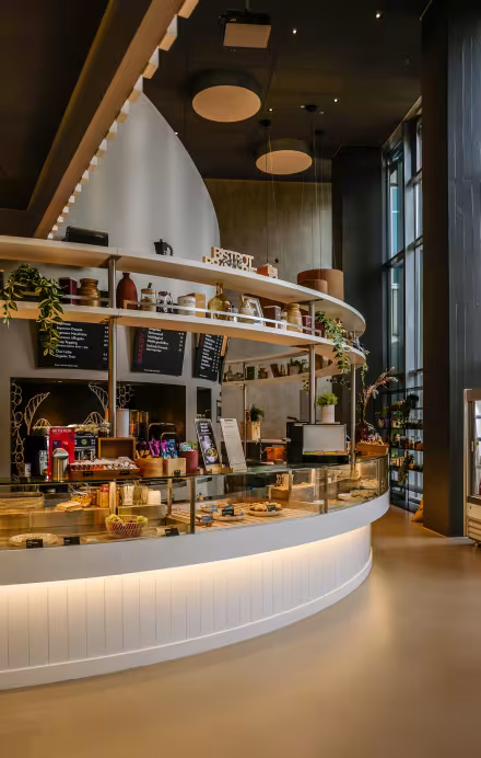 Innenansicht Cafeteriabereich im Restaurant Flavour Kitchen in Werd mit runder moderner Café Bar