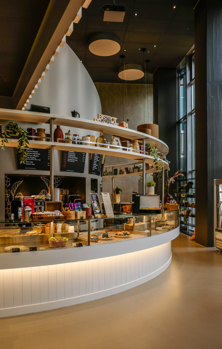 Innenansicht Cafeteriabereich im Restaurant Flavour Kitchen in Werd mit runder moderner Café Bar