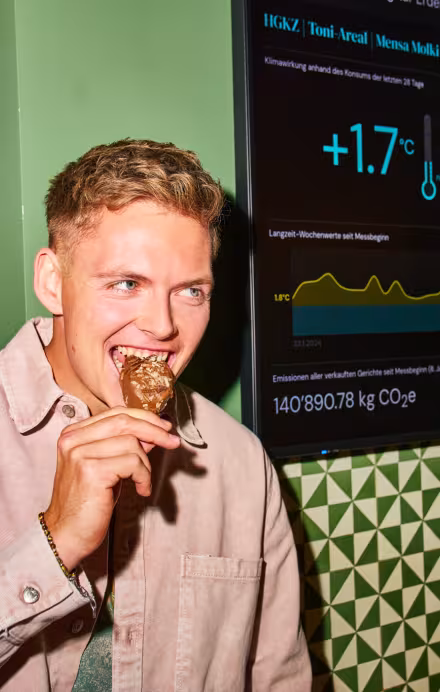 Junger Mann steht vor einem Screen mit Klimawirkung