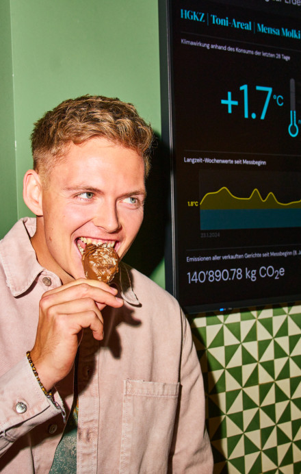 Junger Mann steht vor einem Screen mit Klimawirkung