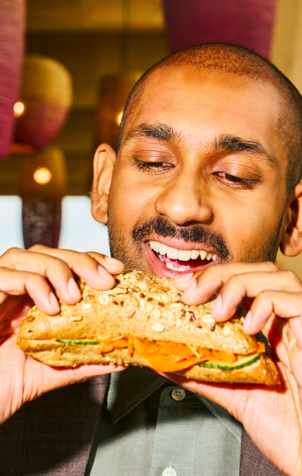 Mann beisst in ein Sandwich.