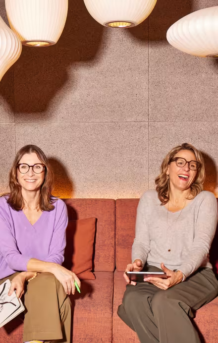 Zwei Frauen sitzen auf einem Sofa in einem Hotel, Interview