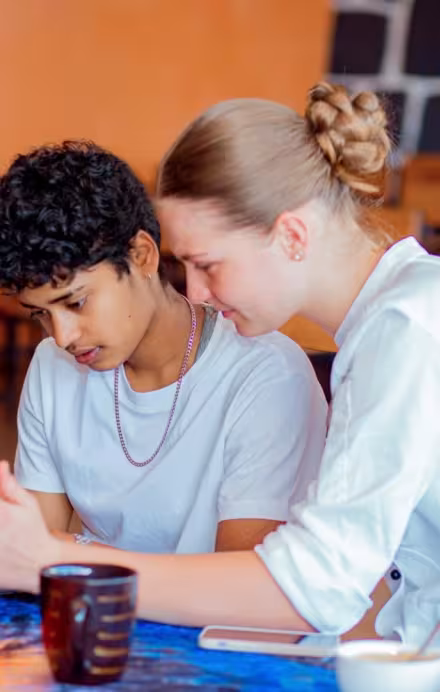 Zwei junge Frauen arbeiten gemeinsam an einem Laptop