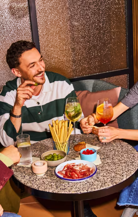 Drei Personen beim Apero an einem Tisch