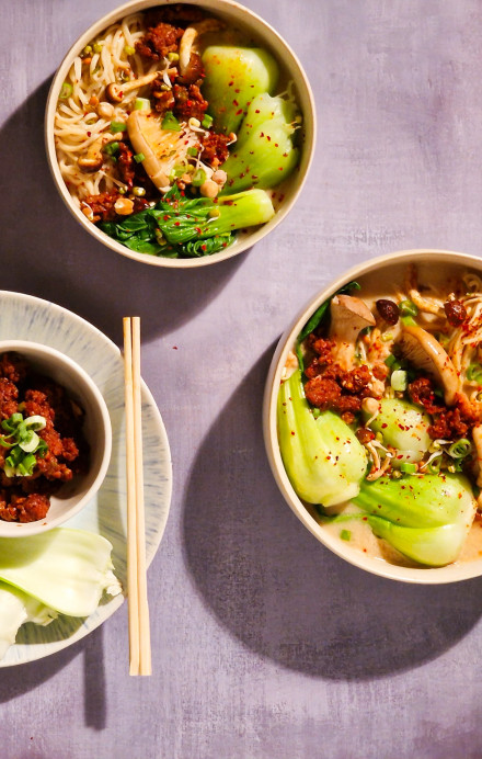 Zwei Schüsseln mit Ramen sowie eine mit Fleisch und eine mit Sojasauce
