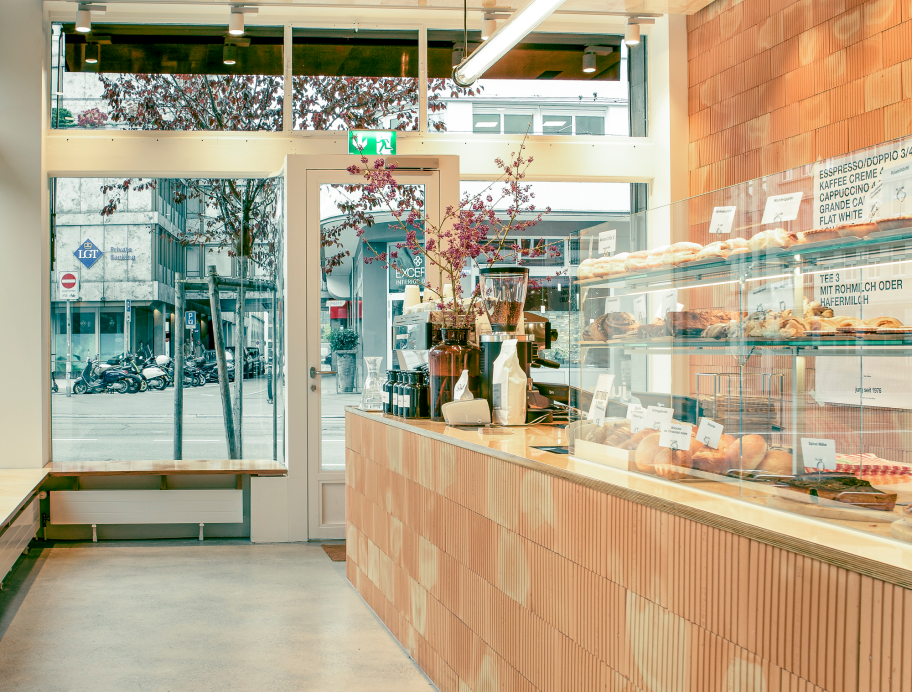 Bäckergeschät mit langem Tresen, heller Boden und künstiches Licht
