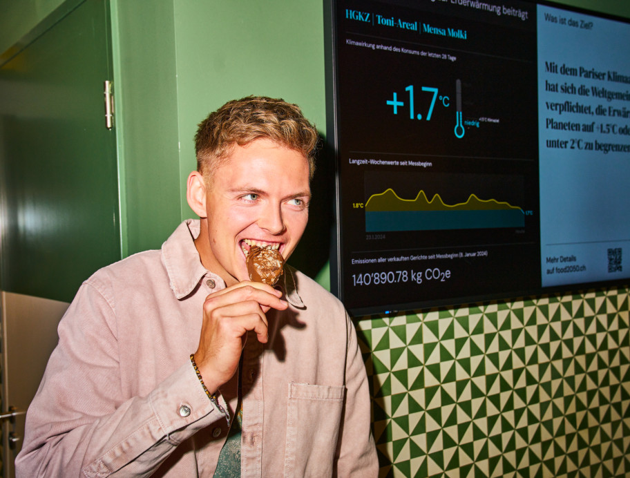 Junger Mann steht vor einem Screen mit Klimawirkung