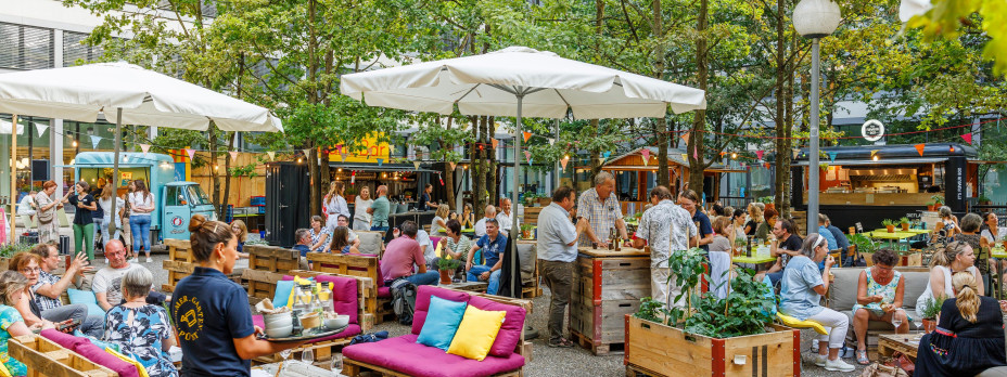 Garten im Freien mit Menschen und Foodtrucks